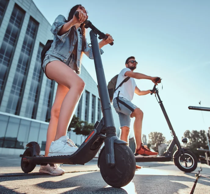 2 people using electric scooters